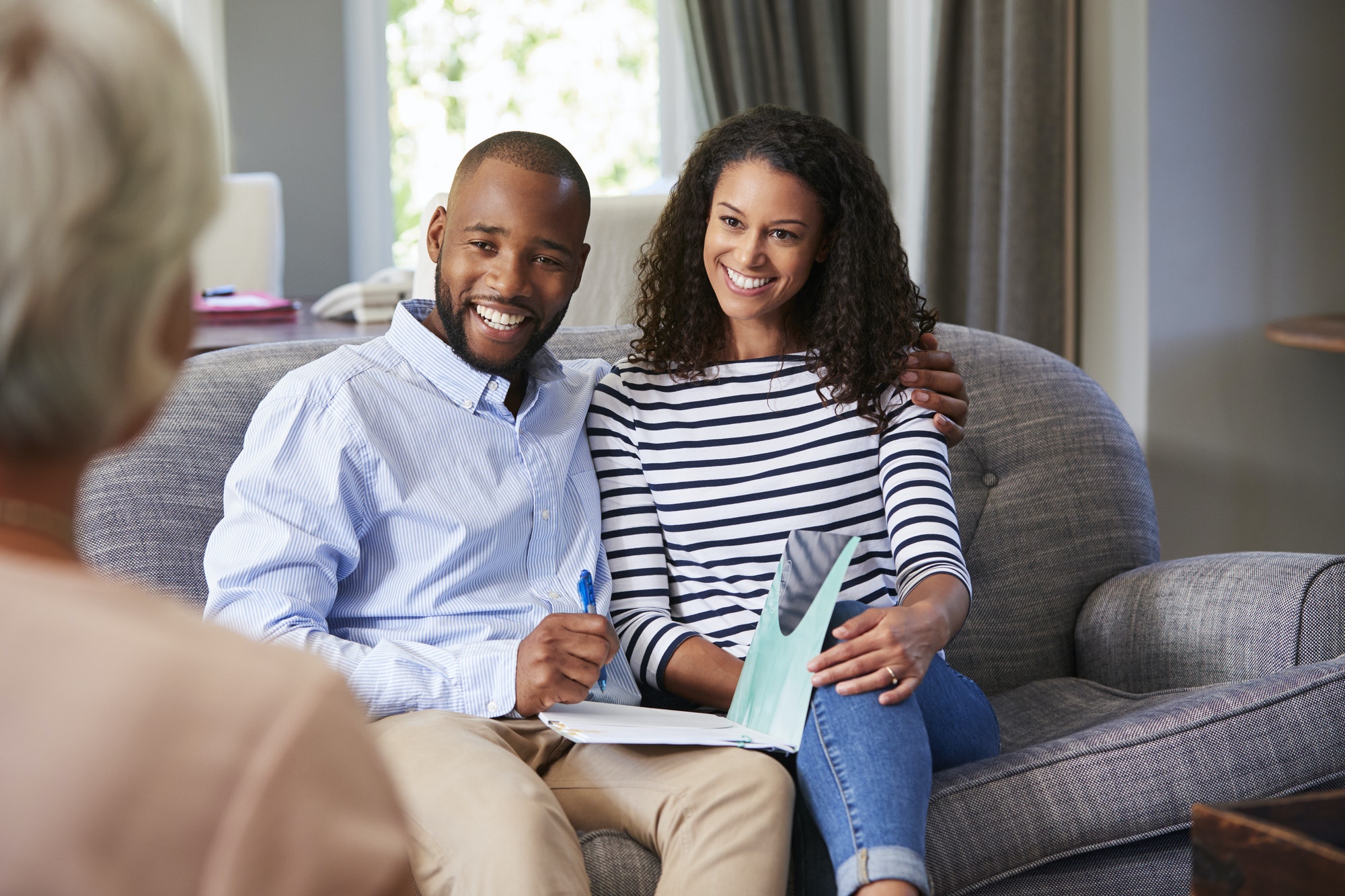 Happy young couple taking financial advice at home